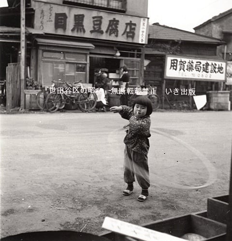 用賀中町通りでフラフープで遊ぶ子供